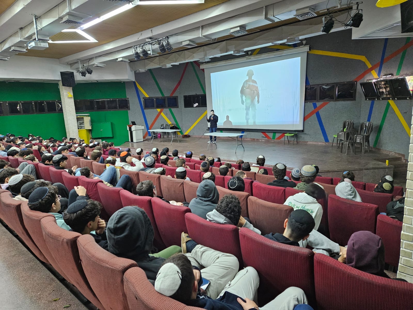 יגל בר מעביר סדנה מול שכבה שלמה באולם בית ספר